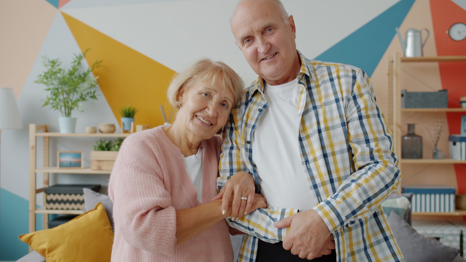 Casal sorrindo em casa, planejando o consórcio
